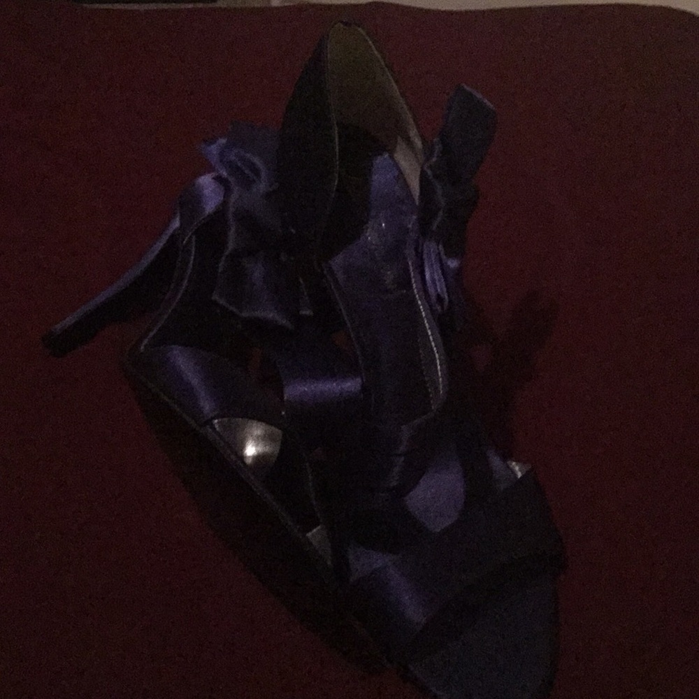Shiny blue high heel shoes with bow on the side.